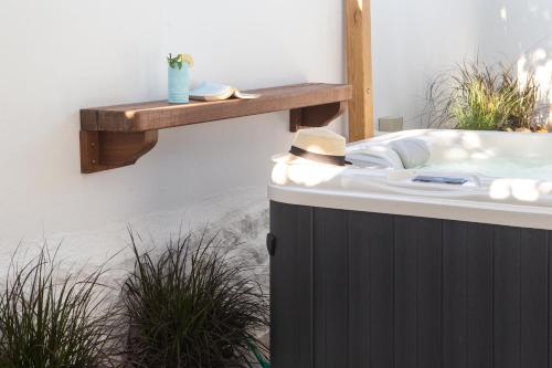 a bath tub with a wooden shelf on a wall at Kallos Villas & Suites in Naxos Chora