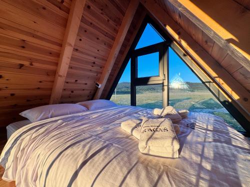 a bed in a room with a large window at Etno House Dragas in Njegovuđa