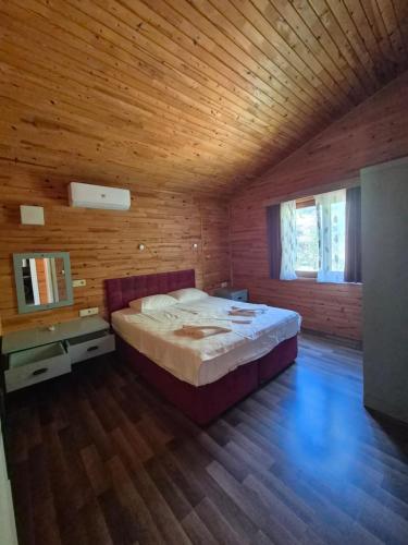 a bedroom with a bed and a wooden ceiling at Azra Villas in Cıralı