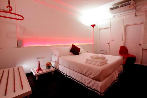 um quarto com uma cama branca e um candeeiro vermelho em U431 Chaengwattana em Nonthaburi