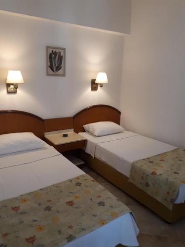 a hotel room with two beds and two lamps at Musti Apart Hotel in Alanya