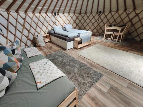 a room with two beds and a couch in a yurt at Jurte Falkenauge Schweiz in Schönengrund