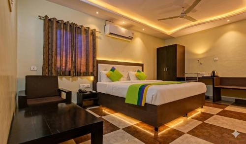 a bedroom with a bed and a chair in it at Jaipur Grand Bella in Jaipur