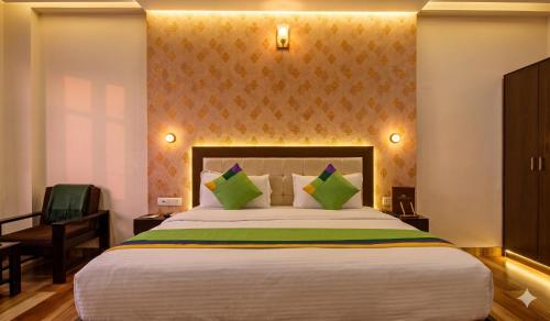 a bedroom with a large bed with green pillows at Jaipur Grand Bella in Jaipur