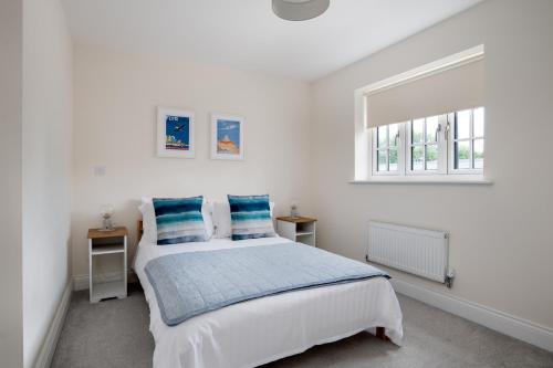 a white bedroom with a bed and a window at Finest Retreats - Field View in Brackley