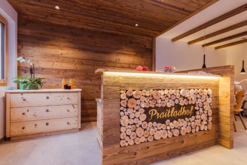 a wooden room with a wooden wall with a rack of logs at Praitladhof in Lana