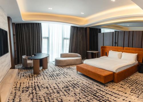 a hotel room with a bed and a chair at Mildom Residence in Almaty