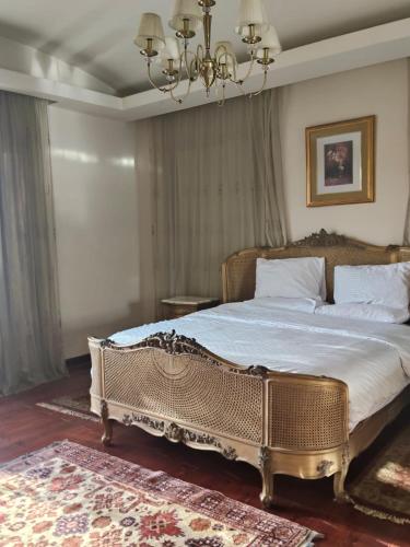 a bedroom with a king sized bed with a chandelier at Heaven new Cairo Villa with Private pool and jacuzzi in Cairo