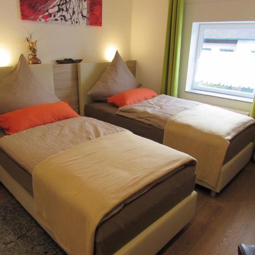 a bedroom with two beds and a window at Eifel Quartier Pension und Gasthof "Em Gardestüffje" in Mechernich
