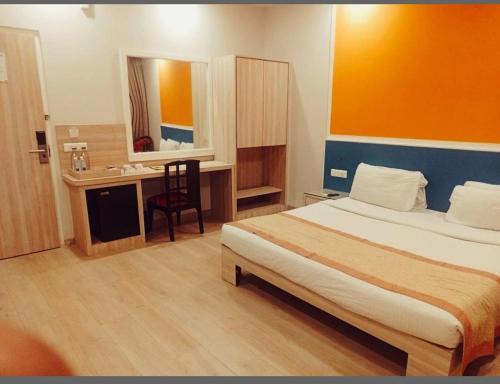 a bedroom with a bed and a desk with a sink at Sparrow Hotels Alwar, Sariska in Alwar