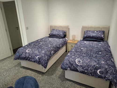 a bedroom with two beds and a night stand at Sleeps2-CentralLocation-FamilyFriendly-NewRefurb in Retford