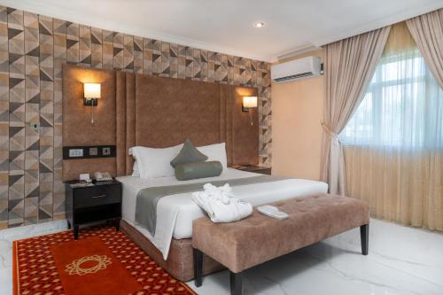 a bedroom with a large bed and a large window at Amber Residence GRA Ikeja in Ikeja
