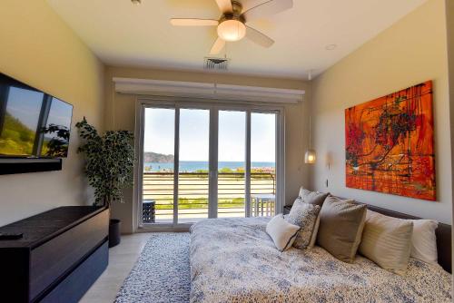 a bedroom with a bed and a large sliding glass door at Miramar 5B 2 bdr Ocean View in Los Suenos in Herradura