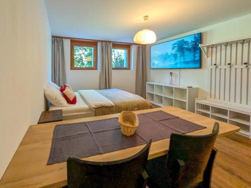 a bedroom with a bed and a table and chairs at PlanB Stay in Silvaplana