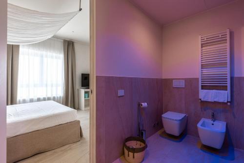 a bedroom with a bed and a tub and a toilet at Regiohotel Manfredi in Manfredonia