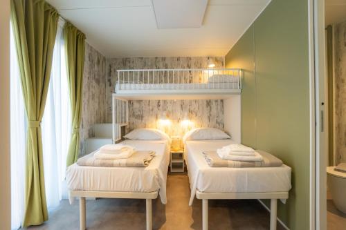 two beds in a small room with green walls at Residence Holidays in Pietra Ligure