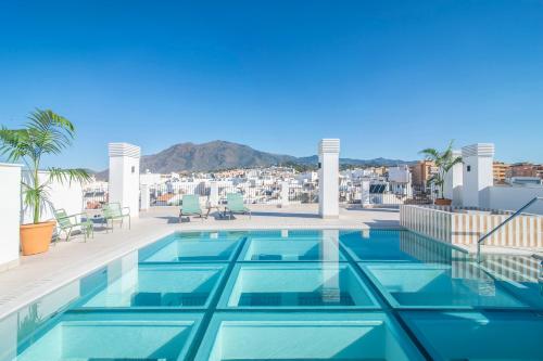 a swimming pool on the roof of a building at Hotel Estepona Patio in Estepona