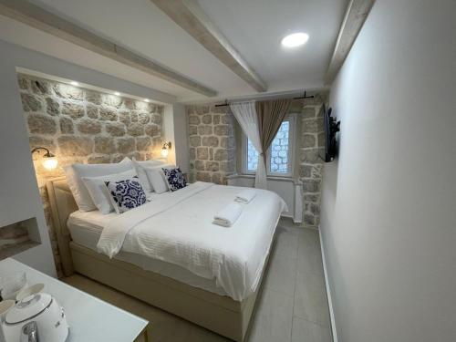 a bedroom with a large bed and a stone wall at StonSoldo Rooms in Ston