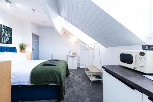 a bedroom with a bed and a microwave on a counter at The Bay by Guestz in Morecambe