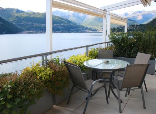 a table and chairs on a balcony with a view of a lake at Residence Il Poggio in Dorio