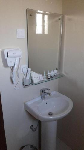 a white bathroom with a sink and a mirror at شقق أجنحة نزيل للشقق المخدومة in Tabuk