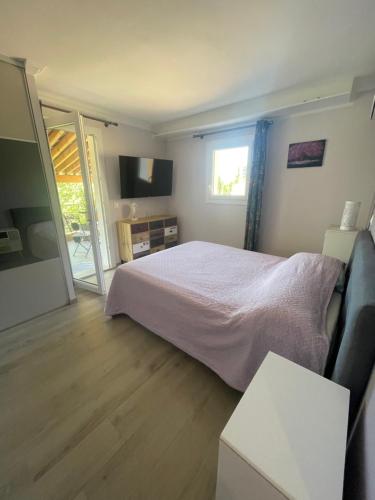 a bedroom with a bed and a sliding glass door at La Bernarde in Tourrettes