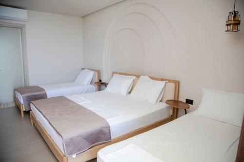 a room with two beds and a table at Uzeiri Guest Hotel in Borsh