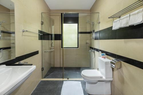 a bathroom with a shower and a toilet and a sink at Serenique Resort Kandy in Kandy