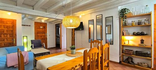 a dining room and living room with a dining table at Donde Elvira in Valderromán
