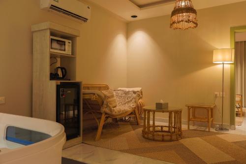 a bathroom with a tub and a table and a chair at شقق وسن الفندقية in Abha