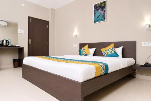a bedroom with a large bed with colorful pillows at Hotel Vilasa Grand in Guwahati