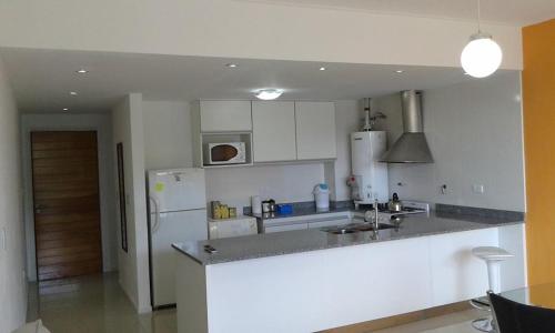 cocina con nevera y encimera en Balcones de Tandil Departamentos en Tandil