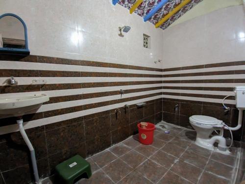a bathroom with a toilet and a sink at White Land Village Stay in Dhordo