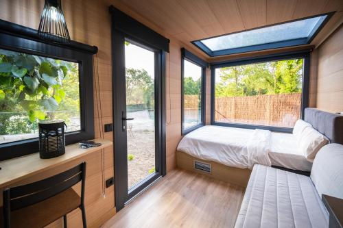 a bedroom in a tiny house with windows at Cabañas en Graus in Graus