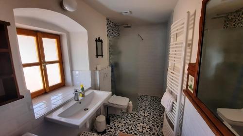 a white bathroom with a sink and a window at Sudetský grunt Autentická jesenická chalupa in Loučná nad Desnou