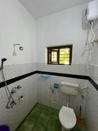 a bathroom with a toilet and a shower at iha ayurveda resort in Varkala
