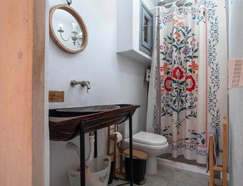 a bathroom with a sink and a toilet and a mirror at Naiada Home with Sea View in Mykonos
