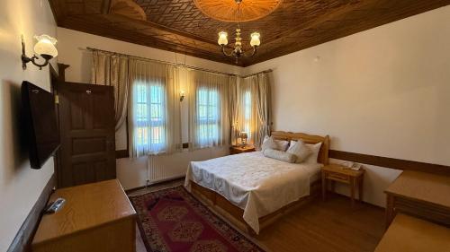 a bedroom with a bed and a chandelier at Rum Evi By Secret Sense Collection in Safranbolu