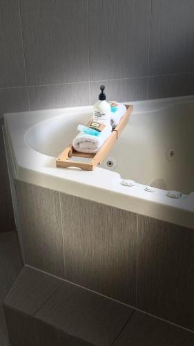 a bathroom with a bath tub with a bottle of soap at Venus Resort in The Entrance