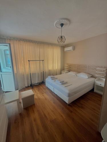 a bedroom with a large white bed and wooden floors at E2 Residence in Balchik