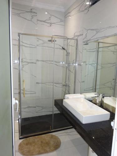 a bathroom with a glass shower and a sink at Room View boutique in Luanda