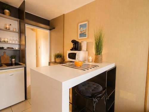a kitchen with a counter with a microwave on it at Appartement entier en centre-ville avec terrasse in La Rochelle