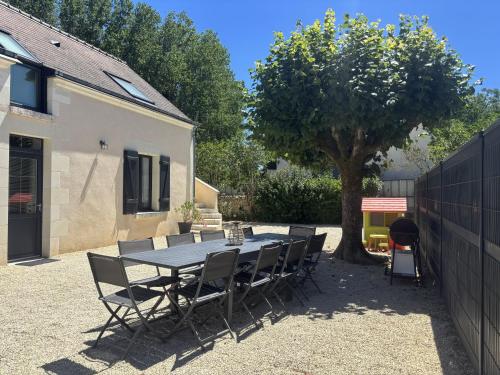 a table and chairs in a yard with a tree at Gîte La Patouille in Amboise