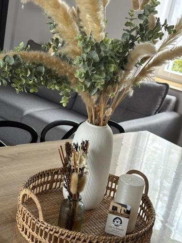 a white vase with flowers on a table at Gîte La Patouille in Amboise