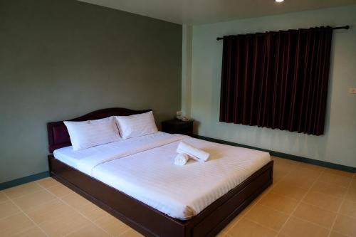 a bedroom with a bed with two towels on it at House Number 3 in Phitsanulok