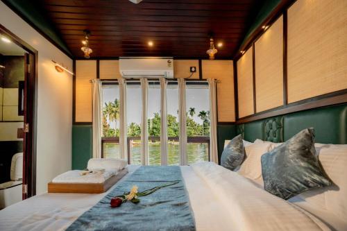a large bed in a room with a large window at Boats N Beds - Alleppey Houseboats - Alleppey Boat House - Luxury Premium Houseboats in Alleppey