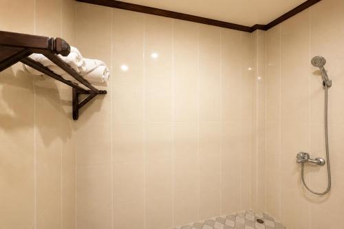 a bathroom with a shower and a toilet and a sink at Luang Prabang Legend Hotel in Luang Prabang