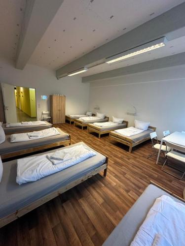 a room with rows of mattresses on the floor at 2-Rent Group Hostel Rooms&Apartments GKP2 in Munich