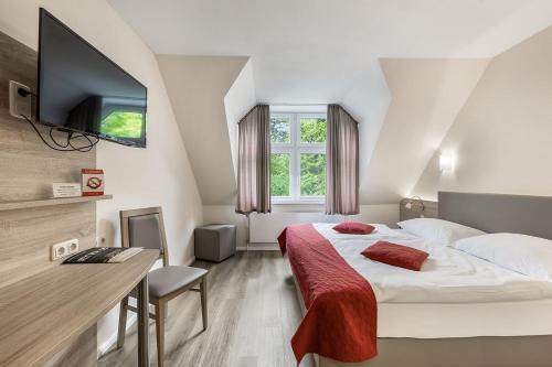 a bedroom with a large bed and a television at Haags Hotel Niedersachsenhof in Verden