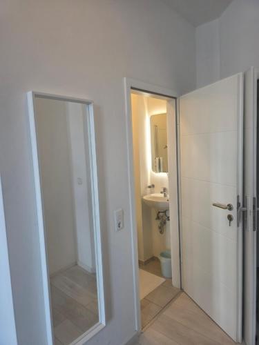 a bathroom with a shower and a toilet and a mirror at City Hotel in Rheinfelden